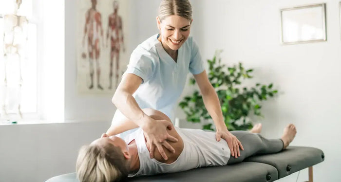 Professionnel de santé accompagnant une femme souffrant de douleurs chroniques liées à la fibromyalgie lors d’une séance de soin naturel