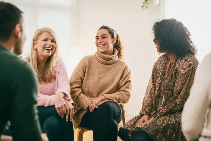 Groupe de femmes souriantes échangeant dans un cadre chaleureux, représentant la communauté CBX Medical entre deux Escales Positives