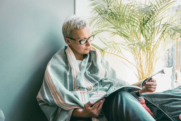 Femme apaisée lisant un dossier thématique CBX Medical pour intégrer des habitudes de bien-être à son quotidien