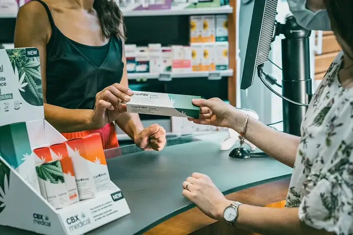 Pharmacienne proposant un produit CBX Medical à une cliente, illustrant l’intégration de solutions naturelles en officine