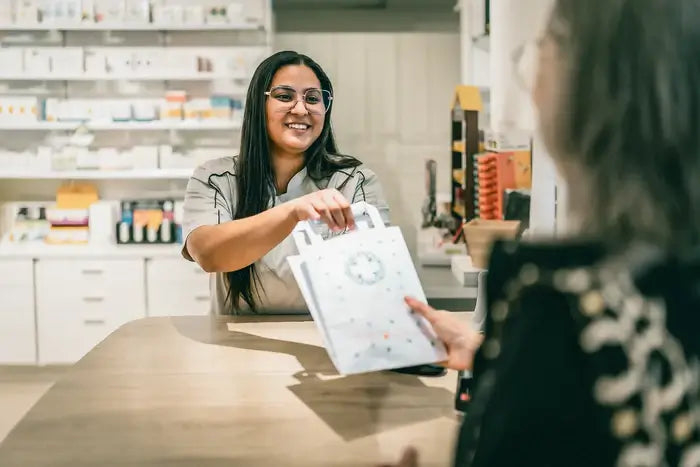 Pharmacienne remettant une cure CBX Medical à une patiente, illustrant l’accessibilité du protocole prescripteur en officine